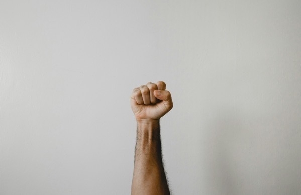 A man's fist extended upright, signifying a sense of self-righteousness.