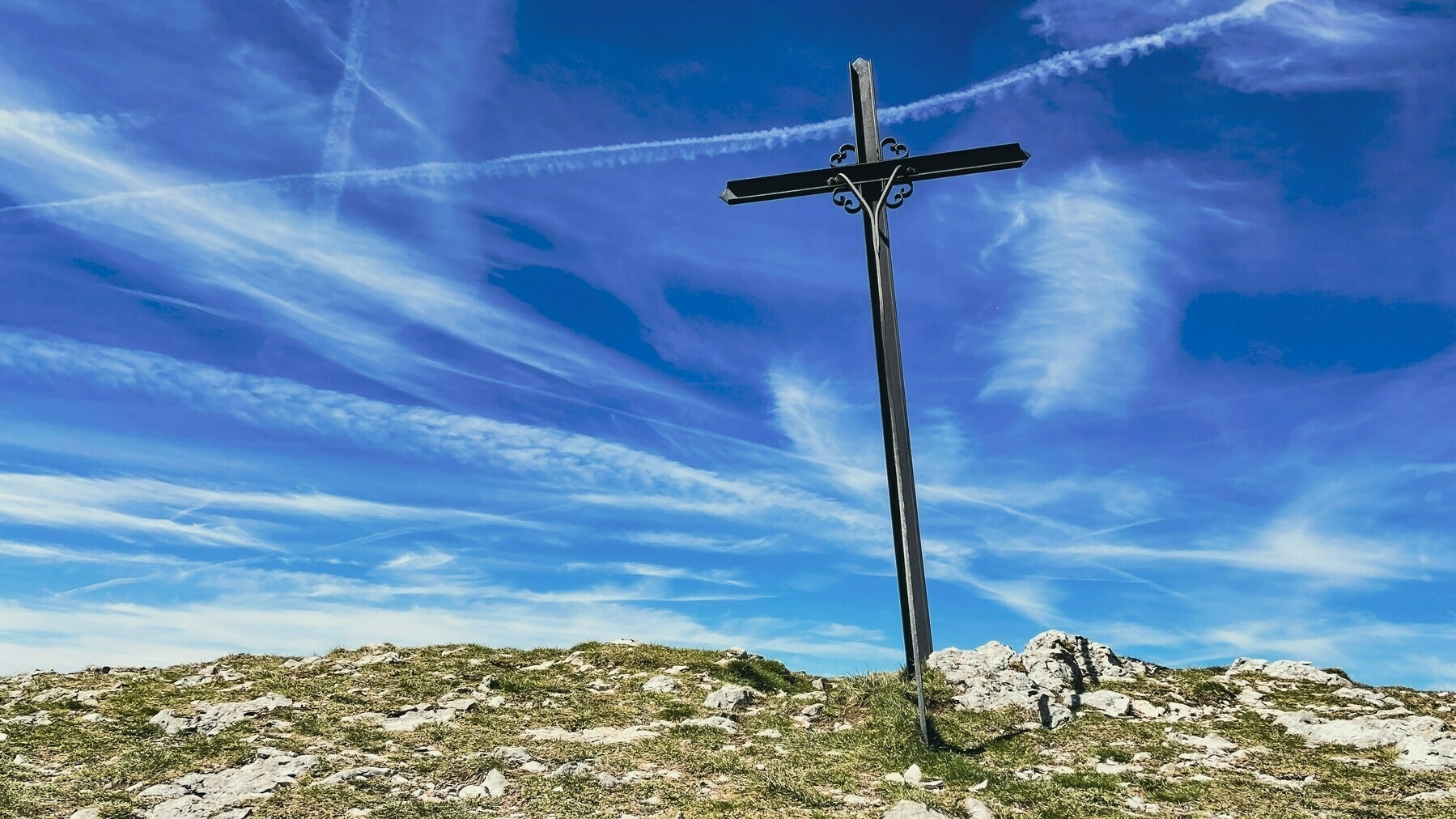 a metal cross on a hillside